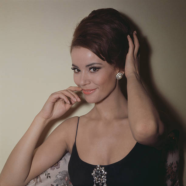 French actress Claudine Auger, who plays the role of Domino Derval in the James Bond film 'Thunderball', posed wearing pearl ear rings and brooch...