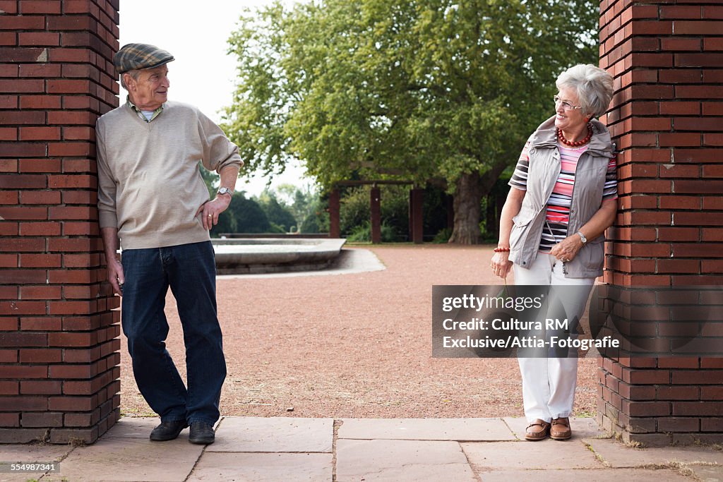 Portrait of senior couple opposite each other in park