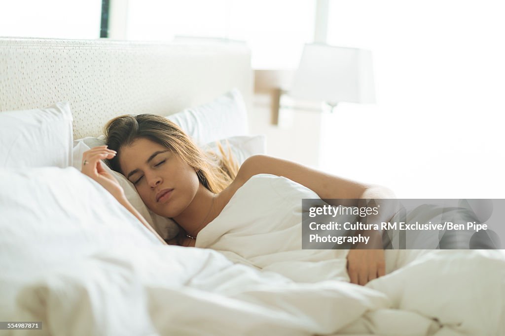 Young woman asleep in hotel bed