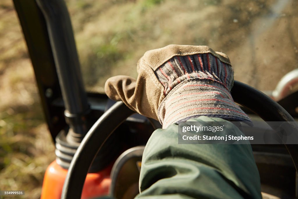 Close up of male hand driving tractor dairy farm field