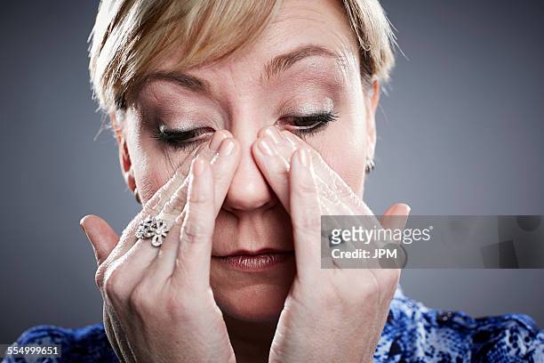 portrait of mature woman, wiping away tears from eyes - eyes crying stock pictures, royalty-free photos & images