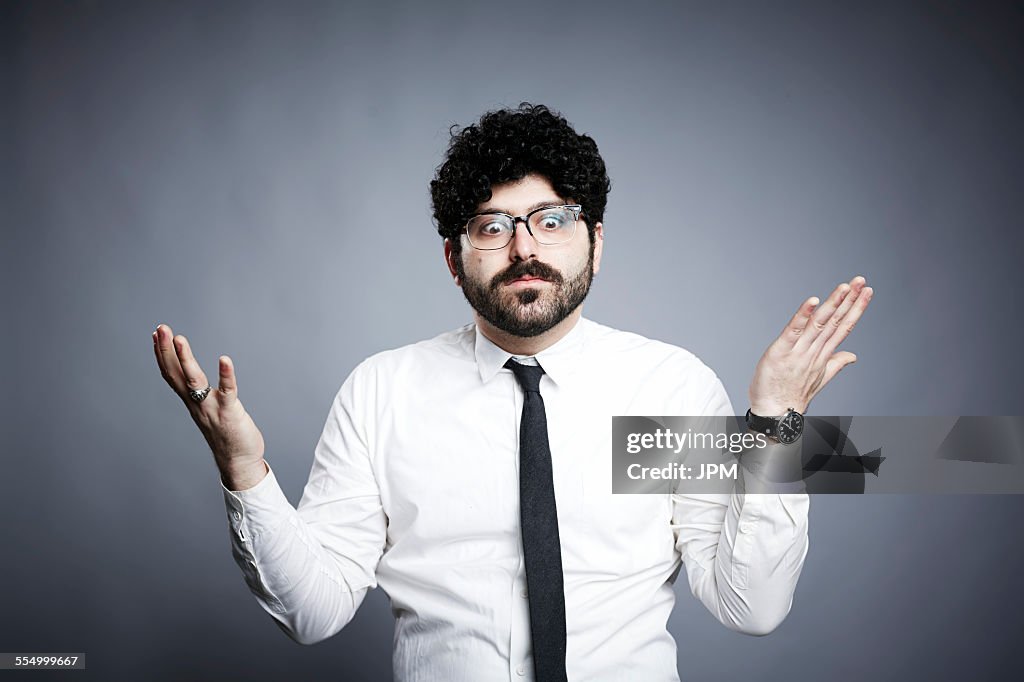Portrait of young man, hands open in questioning expression