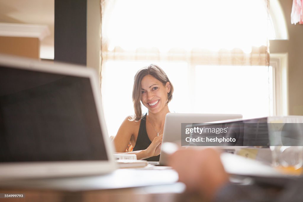 Woman smiling over her work at home