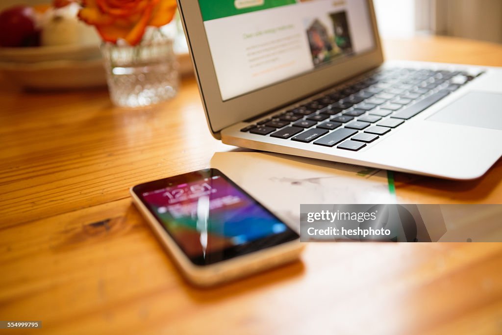 Smartphone and laptop on kitchen table
