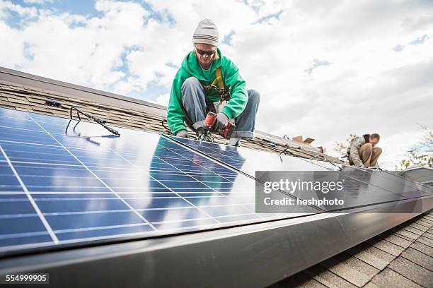 construction crew installing solar panels on a house - heshphoto - fotografias e filmes do acervo