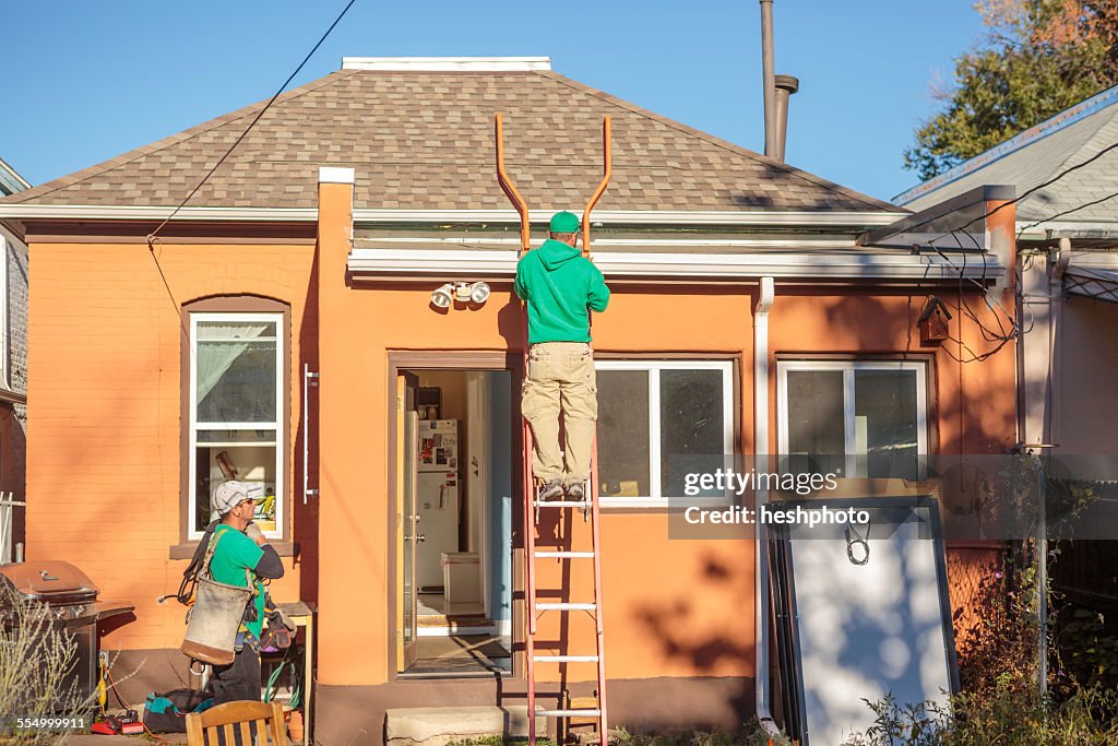 Construction crew installing solar panels on a house