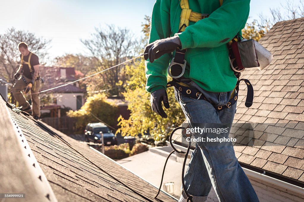 Solar panel installation crew on roof of house