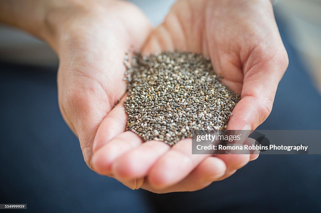 Close up of womans hands holding chia seeds