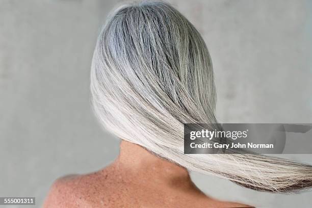 rear view of bare shouldered mature woman with long grey hair - gray hair stock-fotos und bilder