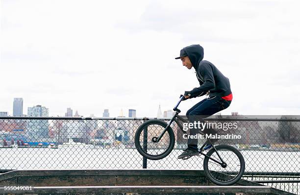 teenage boy riding a bmx bike - ciclismo bmx imagens e fotografias de stock