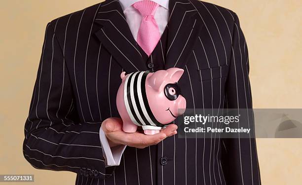 banker/financial advisor with burglar piggy bank - tax fraud 個照片及圖片檔