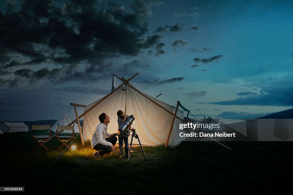 Father and son looking through telescope