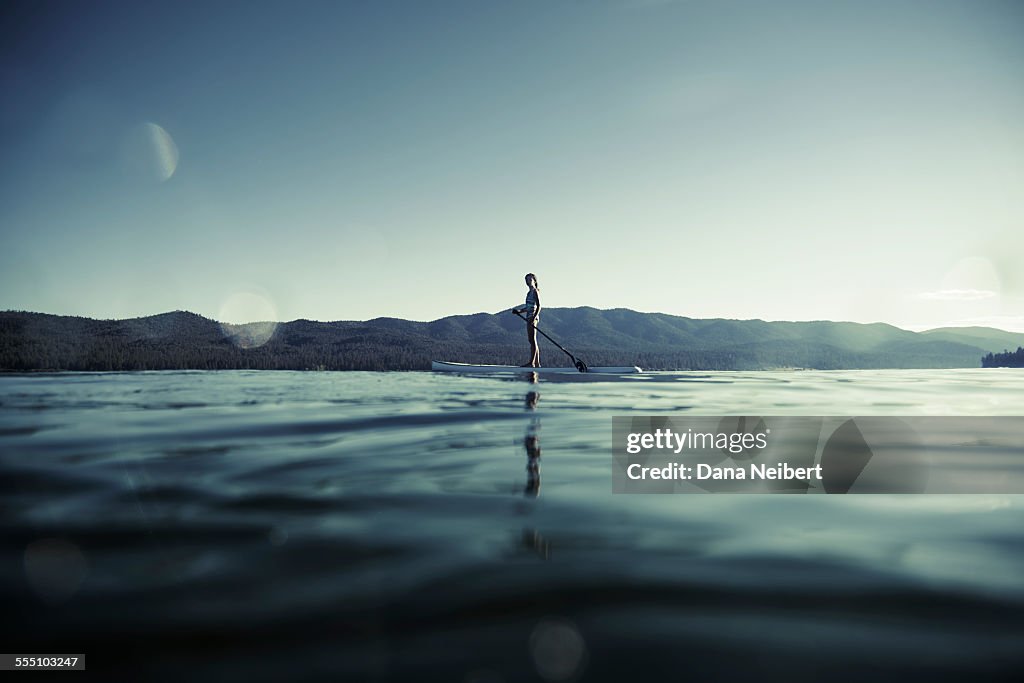 Girl on paddle board on lake