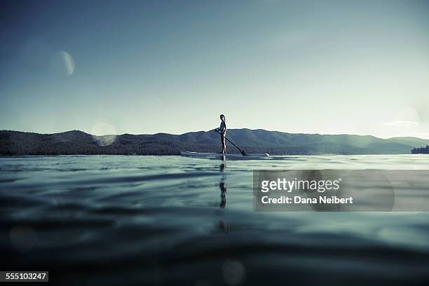 girl on paddle board on lake - horizon over land imagens e fotografias de stock