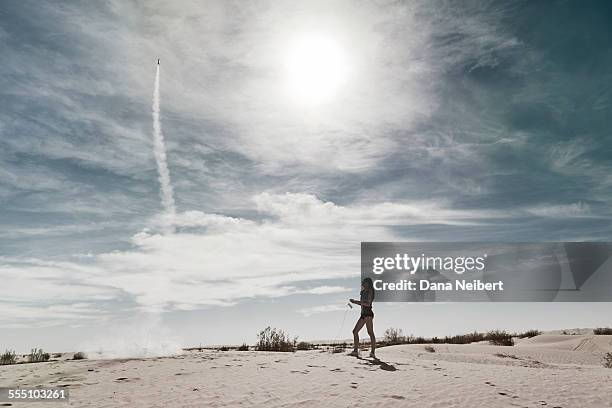 girl launching model hobby rocket in desert - missile launch stock pictures, royalty-free photos & images