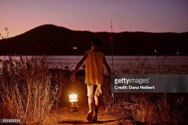 boy with lantern and fishing rod & tackle on lake - lantern water stock-fotos und bilder