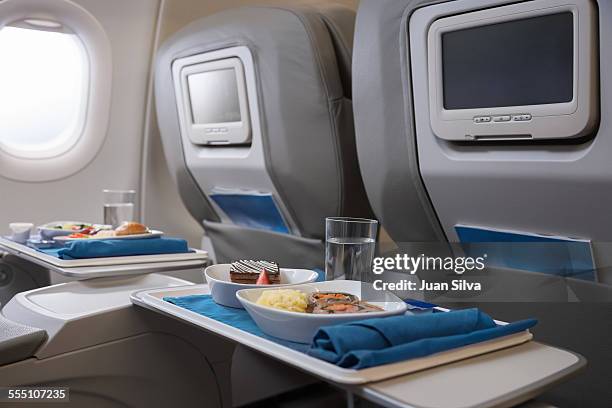 airline meals served on seat tables - first class plane stockfoto's en -beelden