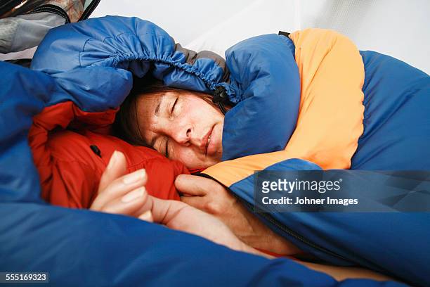 woman sleeping in sleeping bag - mid adult women stock pictures, royalty-free photos & images