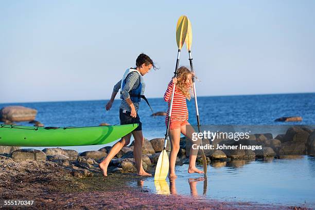 mother with daughter at sea - carrying canoe stock pictures, royalty-free photos & images