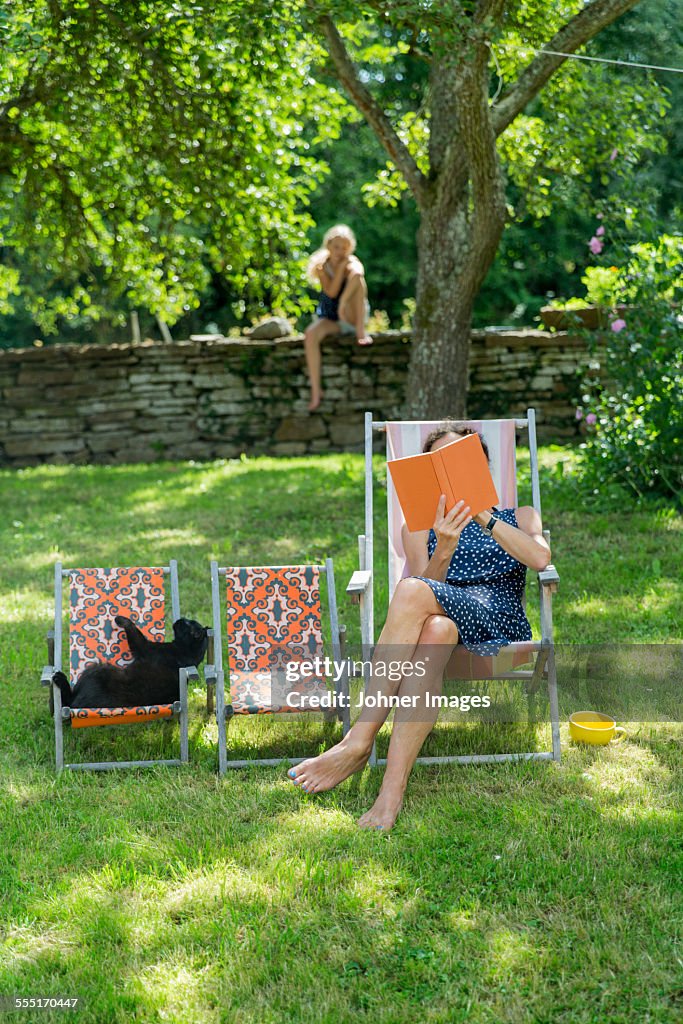 Woman reading book on sun chair