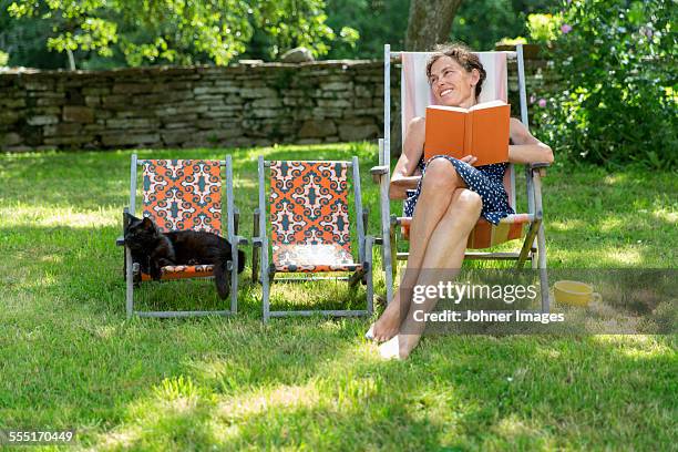 smiling woman on sun chair - stone wall garden stock pictures, royalty-free photos & images