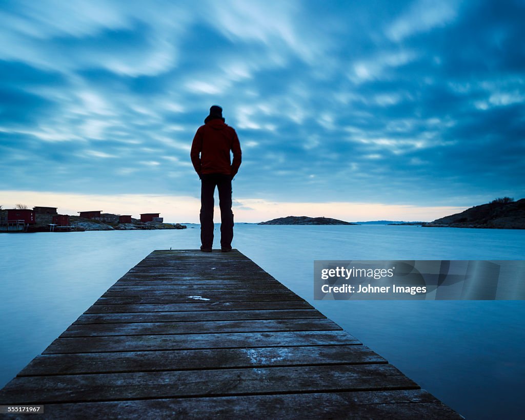 Man on jetty looking at view