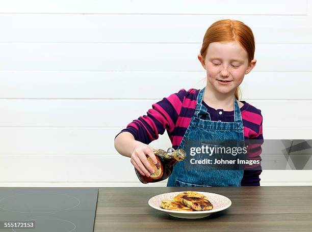 girl pouring maple syrup on pancakes - maple syrup pancakes fotografías e imágenes de stock