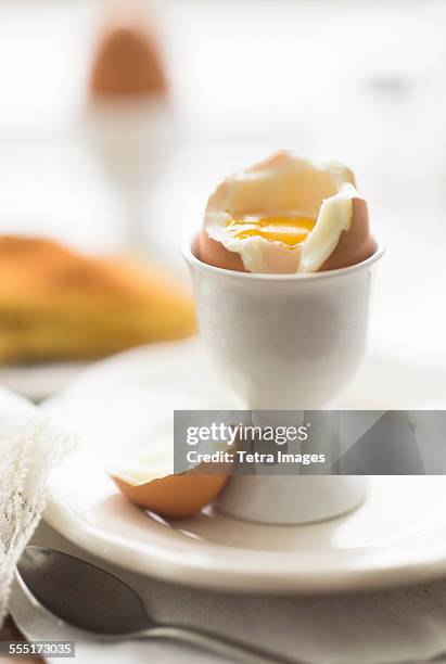 close up of soft boiled egg in egg cup - eierbecher stock-fotos und bilder