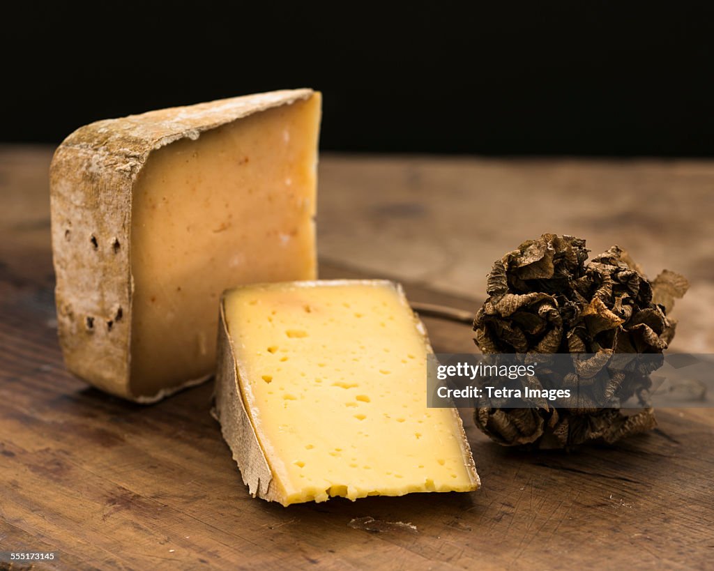 Hard cheese slices and truffle on wooden table, studio shot