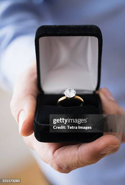 close up of mans hand holding open box with engagement ring - engagement ring box - fotografias e filmes do acervo