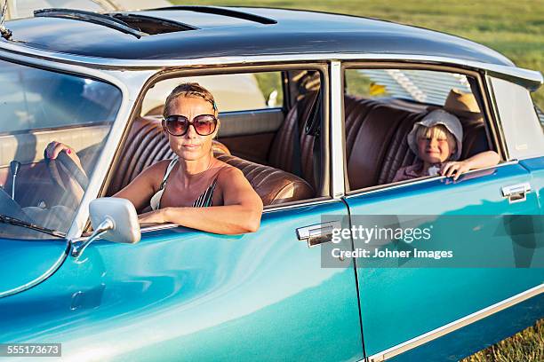woman with daughter in vintage car - carro antigo imagens e fotografias de stock