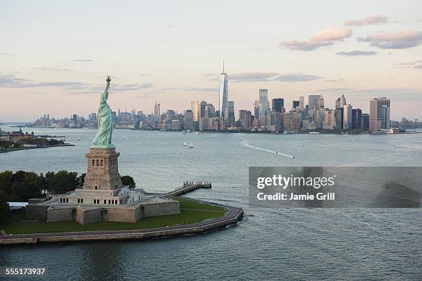 usa, new york state, new york city, aerial view of statue of liberty and city skyline - new york freiheitsstatue stock-fotos und bilder