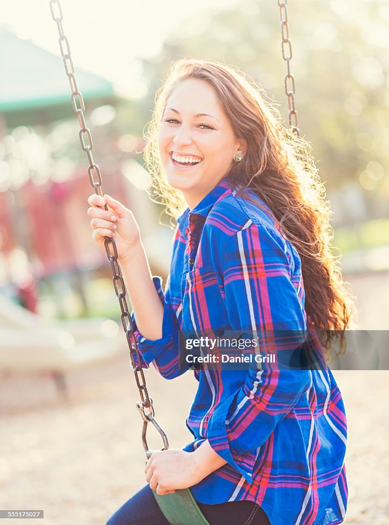 USA, Florida, Jupiter, Woman swinging in playground