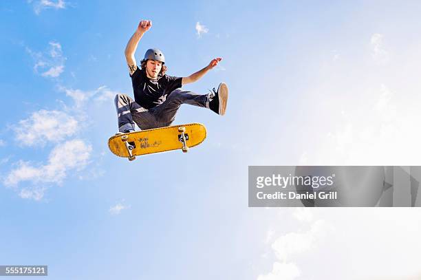 usa, florida, west palm beach, man jumping on skateboard against sky and clouds - skateboard bildbanksfoton och bilder