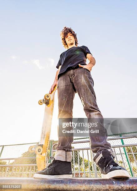 usa, florida, west palm beach, man leaning on skateboard in skatepark - low angle view ストックフォトと画像