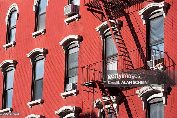 usa, new york, new york city, facade of red building with fire escape - apartment exterior ストックフォトと画像