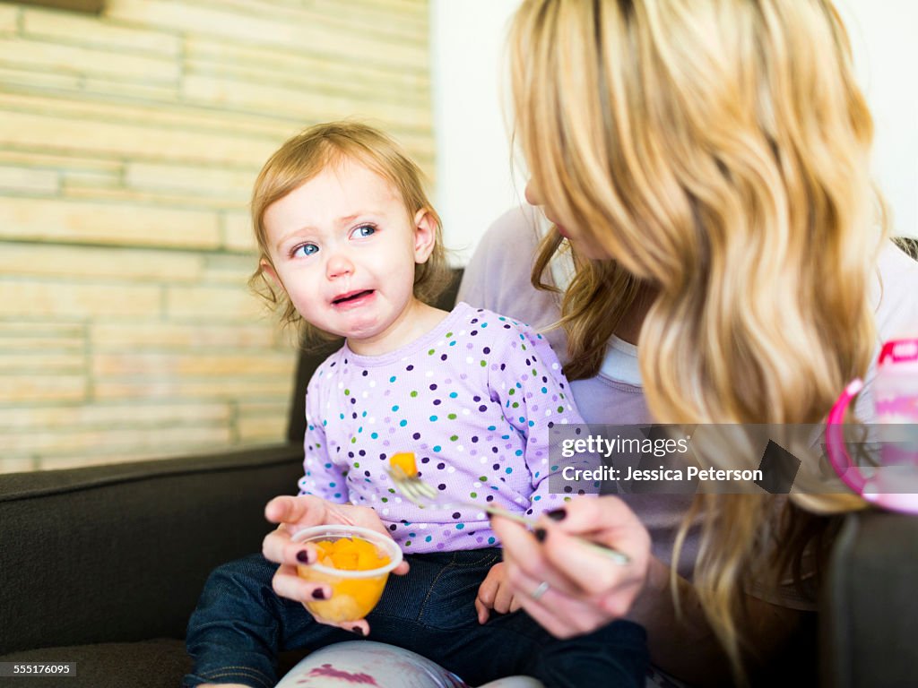 USA, Utah, Salt Lake City, Woman feeding her daughter (12-17 months)