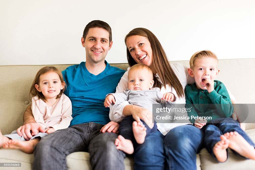 USA, Utah, Salt Lake City, Portrait of family with three children (2-3, 4-5) sitting on sofa