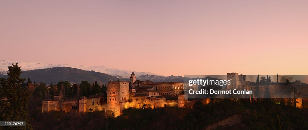 Spain, Andalucia, Granada, Alhambra, Cityscape with illuminated castle at dusk, pink sky