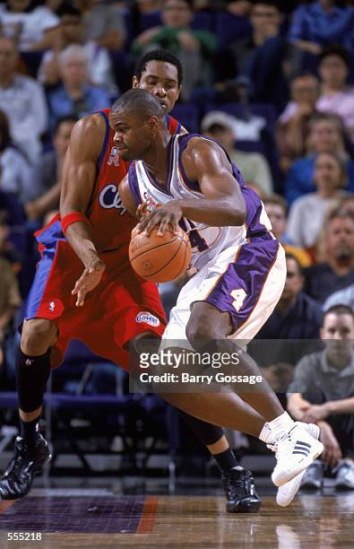 Forwad Alton Ford of the Phoenix Suns dribbles the ball around center Michael Olowokandi of the Los Angeles Clippers during the NBA game at the...