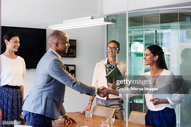 happy business people shaking hands - international day four stock pictures, royalty-free photos & images