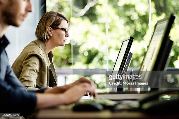 businesswoman using computer in office - werken stockfoto's en -beelden
