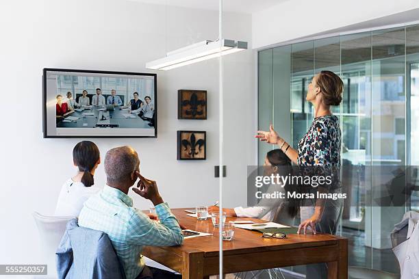 business people video conferencing in board room - board room meeting stockfoto's en -beelden