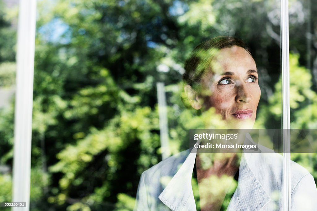 Thoughtful businesswoman by glass window