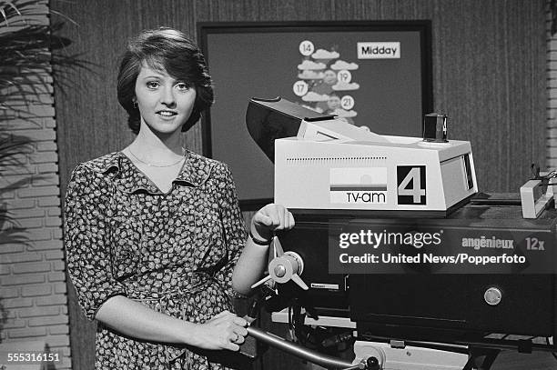 English journalist and presenter on the TV-am breakfast television show Good Morning Britain, Anne Diamond pictured standing beside a television...