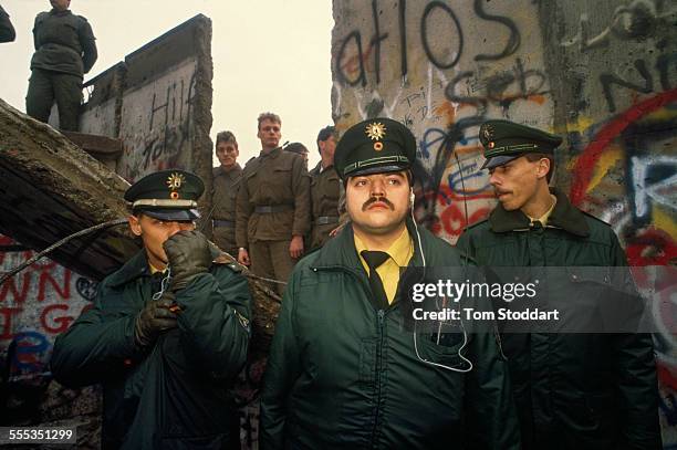 West German Police securing the area around the first section of the Berlin Wall to be torn down by crowds near the Brandenburg Gate on the morning...