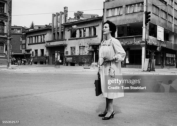 Well dressed woman waits for the shooting to stop before running across 'Sniper Alley' during the siege of Sarajevo in 1995. Many citizens have been...