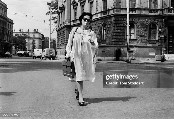 Well dressed woman runs across 'Sniper Alley' during the siege of Sarajevo in 1995. Many citizens have been killed in the area running across the...