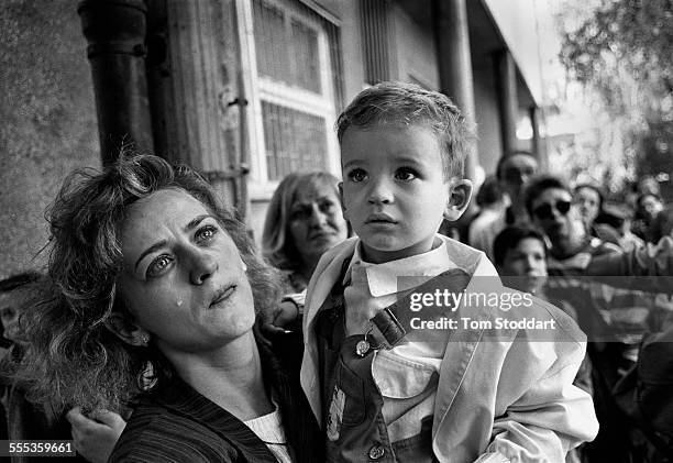 Tears of anguish for a mother as she prepares to send her confused child out of Sarajevo on a bus promised safe passage by the Serb forces during the...