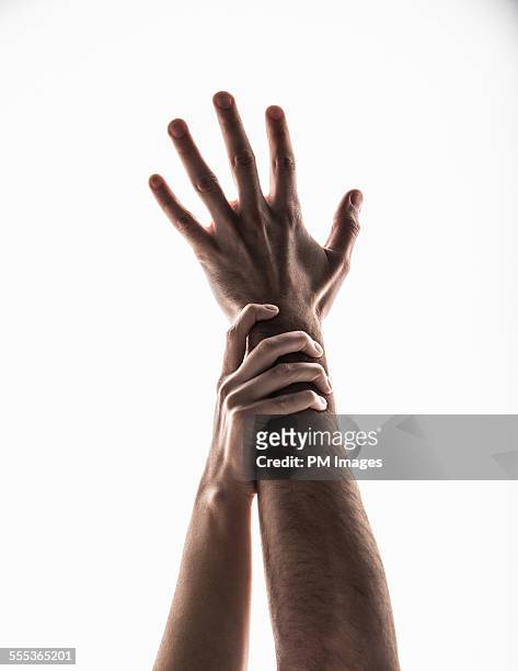 reaching hands - gripping arm stock pictures, royalty-free photos & images